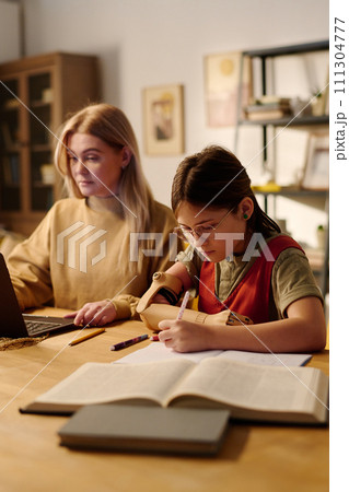 Girl with disability making notes 111304777