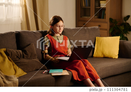 Schoolgirl with laptop on her knees 111304781