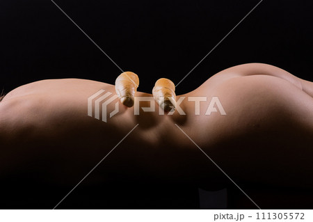Female sensual body holding one big white bread bun with sesame seeds, horizontal picture 111305572