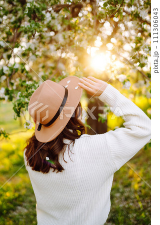 Beautiful young woman near blooming spring tree. Youth, love, fashion, romantic, lifestyle concept. 111306043