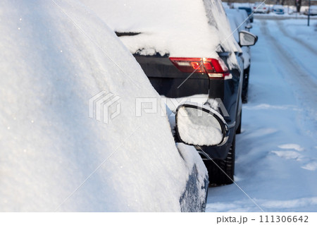 Line of Cars Covered in Snow on a Street 111306642