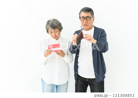 通帳と財布を持って悩むシニア夫婦 通帳と財布を持って悩むシニア夫婦 111308851