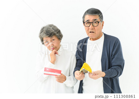通帳と財布を持って悩むシニア夫婦 通帳と財布を持って悩むシニア夫婦 111308861
