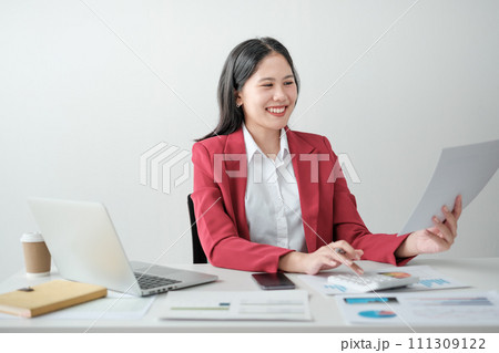 Portrait of smile beautiful business asian woman in red suit working office desk computer. Small business sme . Portrait of smile beautiful business asian woman in red suit working office desk computer. Small business sme . 111309122