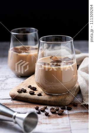 Traditional Irish cream coffee liqueur with ice on wooden table Traditional Irish cream coffee liqueur with ice on wooden table 111309264