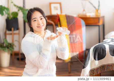 部屋でスキンケアをする大学生の女性 部屋でスキンケアをする大学生の女性 111309461