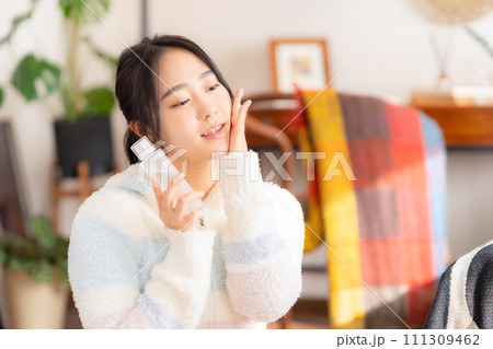 部屋でスキンケアをする大学生の女性 部屋でスキンケアをする大学生の女性 111309462