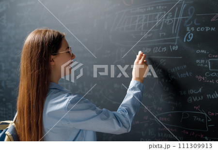 Teenager in class on background of blackboard Teenager in class on background of blackboard 111309913