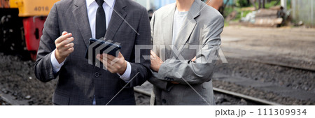 Young caucasian engineer man and woman in suit checking train with tablet in station. Young caucasian engineer man and woman in suit checking train with tablet in station. 111309934