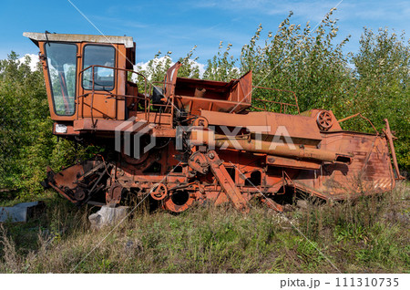 Old rusty agricultural machinery. Abandoned harvester, tractor Old rusty agricultural machinery. Abandoned harvester, tractor 111310735