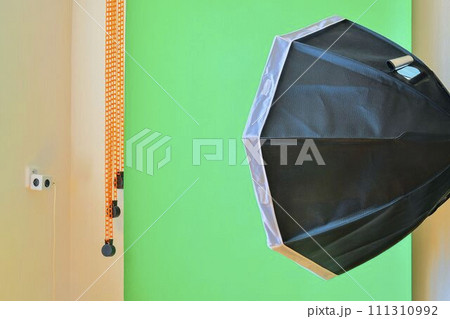Empty photo studio with lighting equipment. Green background in photo studio Empty photo studio with lighting equipment. Green background in photo studio 111310992