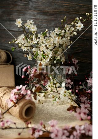 Spring twigs with flowers in a jar, on a dark wooden background. Spring twigs with flowers in a jar, on a dark wooden background. 111311979