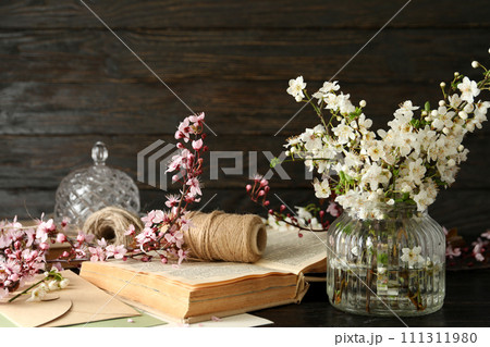 Spring twigs with flowers in a jar, on a dark wooden background. Spring twigs with flowers in a jar, on a dark wooden background. 111311980