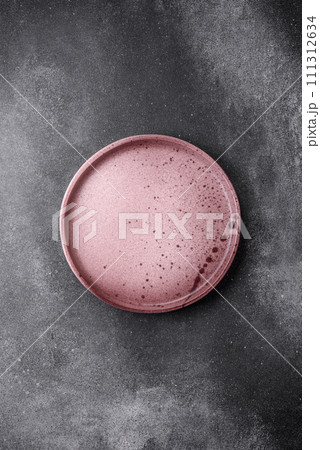 Empty round ceramic plate on a light texture background Empty round ceramic plate on a light texture background 111312634