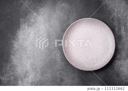 Empty round ceramic plate on a light texture background 111312662