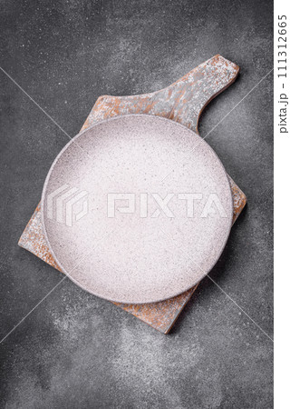 Empty round ceramic plate on a light texture background Empty round ceramic plate on a light texture background 111312665