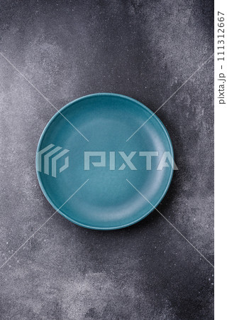 Empty round ceramic plate on a light texture background Empty round ceramic plate on a light texture background 111312667