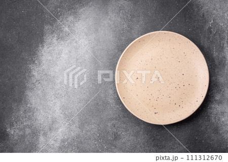 Empty round ceramic plate on a light texture background Empty round ceramic plate on a light texture background 111312670