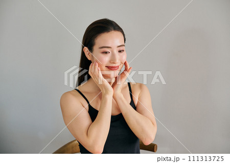 顔をマッサージして肌のお手入れをする30代女性 顔をマッサージして肌のお手入れをする30代女性 111313725