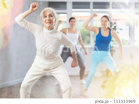 Happy women practicing aerobics in light fitness studio 111313969