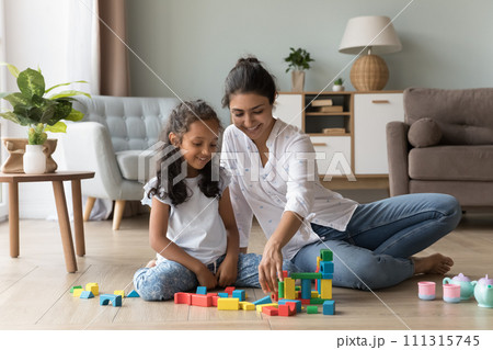 Indian mom play wooden cubes with daughter at home 111315745
