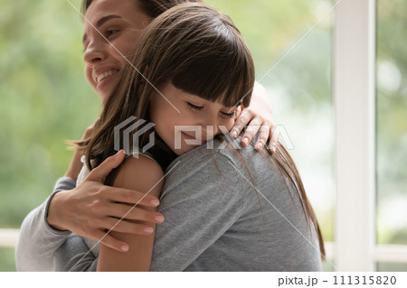 Smiling young mother hugging adorable little daughter close up 111315820