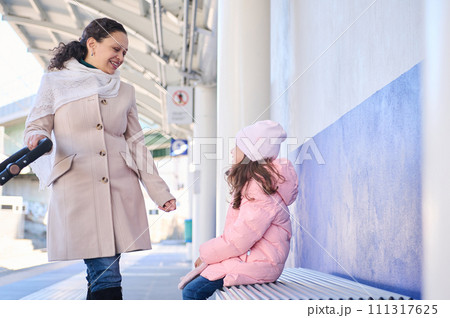 Mother and daughter waiting high-speed train in the train station 111317625