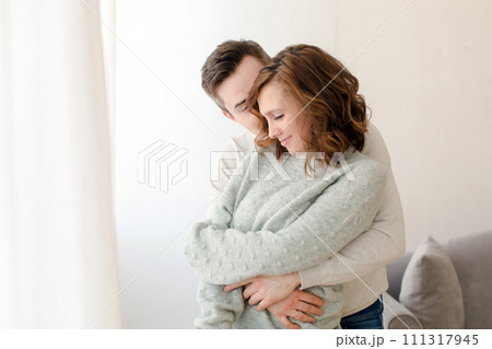 Romantic couple hugging and kissing at home during weekend Romantic couple hugging and kissing at home during weekend 111317945