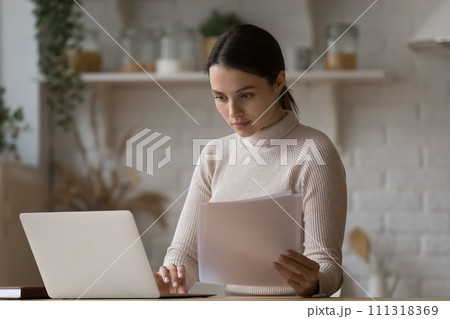 Woman do paperwork, paying household bills via e-bank using laptop 111318369