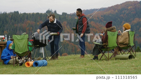Caucasian man cooks in barbecue grill on the hill for friends and kids 111318565