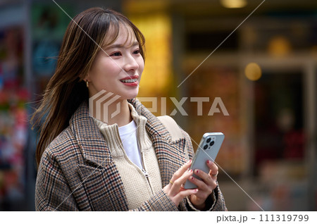 スマホを持つ冬服の若い女性 スマホを持つ冬服の若い女性 111319799