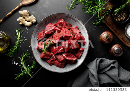 Beef meat entrecote sliced, raw beef meat fillet on black background, top view Beef meat entrecote sliced, raw beef meat fillet on black background, top view 111320528