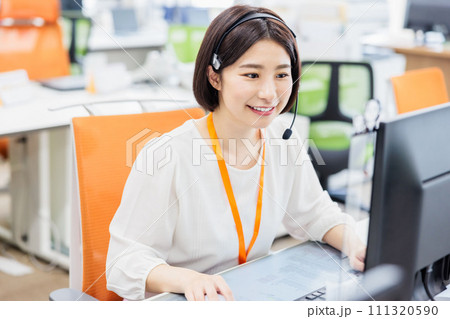 電話を受けるコールセンターのオペレーター 111320590