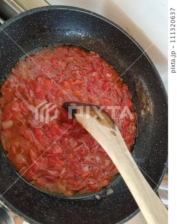 A Frying Pan Filled With Tomato Sauce And A Wooden Spoon. Tomato Sausage 111320637