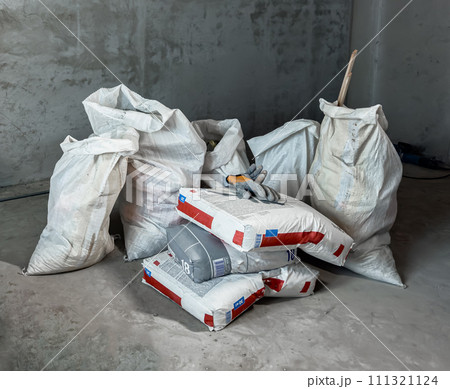 Building garbage, waste bags in empty room, apartment during renovation Building garbage, waste bags in empty room, apartment during renovation 111321124