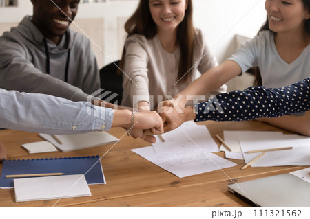 Smiling multiracial students join hands show unity 111321562