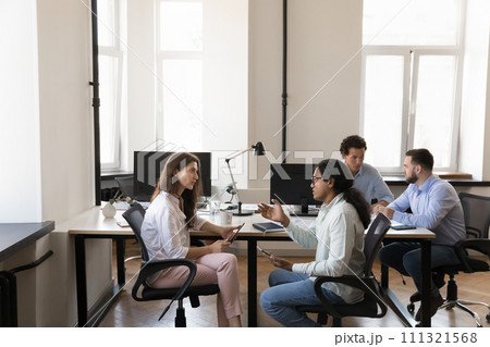 Pairs of busy multiethnic office colleagues talking at shared workplace 111321568