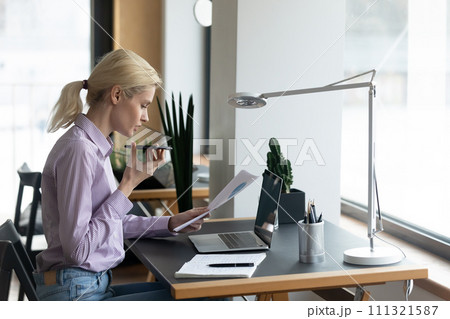 Young woman consult client on smartphone loudspeaker Young woman consult client on smartphone loudspeaker 111321587