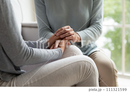 Close up daughter holding mature mother hands, support and care Close up daughter holding mature mother hands, support and care 111321599