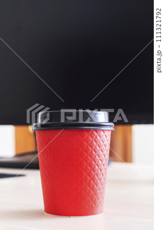 Red plastic coffee cup on the desktop 111321792