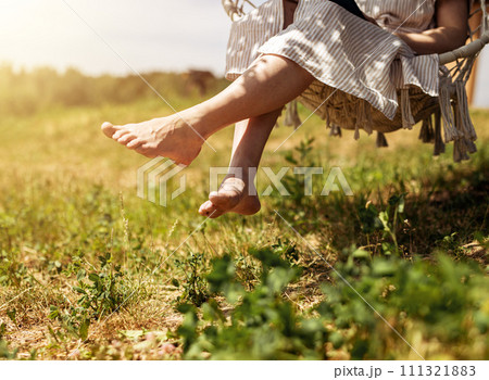 Women legs, feet on summer holiday. Barefoot girl relaxing, resting outdoors in nature on sunny day 111321883