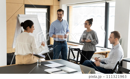 Diverse employees discuss whiteboard presentation in office 111321963