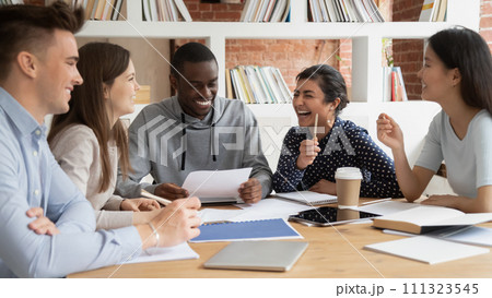Overjoyed multiethnic students laugh studying together in class 111323545