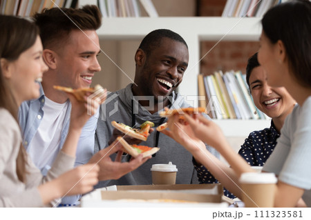 Overjoyed multiracial young people have fun eating pizza 111323581