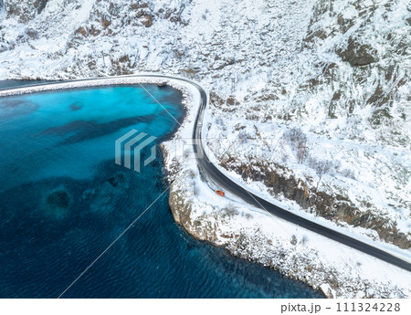 Aerial view of curved snowy road to the island and blue sea 111324228