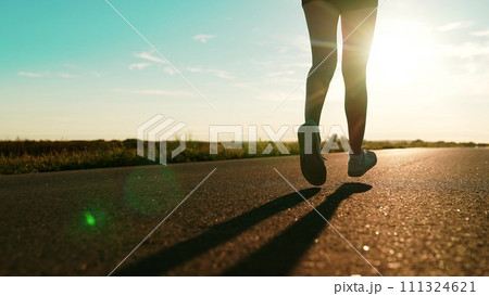 silhouette sports girl running along road sunset, legs close-up, well-being running, sportswoman morning jogging, runner training, healthy fitness lifestyle, sports runner, mindful running, running silhouette sports girl running along road sunset, legs close-up, well-being running, sportswoman morning jogging, runner training, healthy fitness lifestyle, sports runner, mindful running, running 111324621
