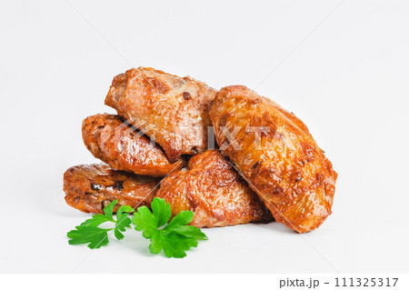 Chicken wings fried until half cooked, semi-finished product with fresh herbs on a white background. Fast food. Quick cooking at home. Copy space.Fast cooking.Fast homemade food. 111325317