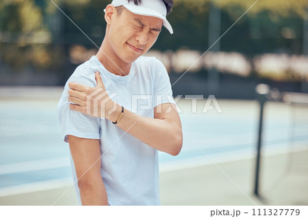 Tennis arm, man and pain on the court while playing competitive and intense game workout outside. Inflammation, accident and injury at sports training practice with asian athlete holding muscle. Tennis arm, man and pain on the court while playing competitive and intense game workout outside. Inflammation, accident and injury at sports training practice with asian athlete holding muscle. 111327779