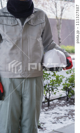 ネックウォーマーで防寒対策をする作業服の男性と積雪風景 ネックウォーマーで防寒対策をする作業服の男性と積雪風景 111327887