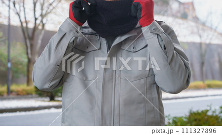 ネックウォーマーで防寒対策をする作業服の男性と積雪風景 ネックウォーマーで防寒対策をする作業服の男性と積雪風景 111327896